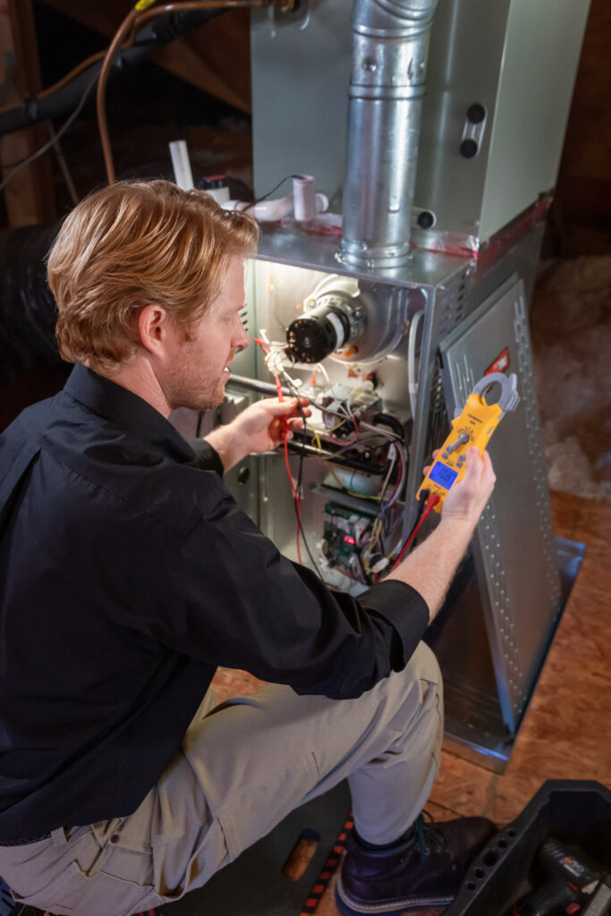 trane-11-24-attic-176b-jb_250225081332 Technician servicing a furnace in an attic